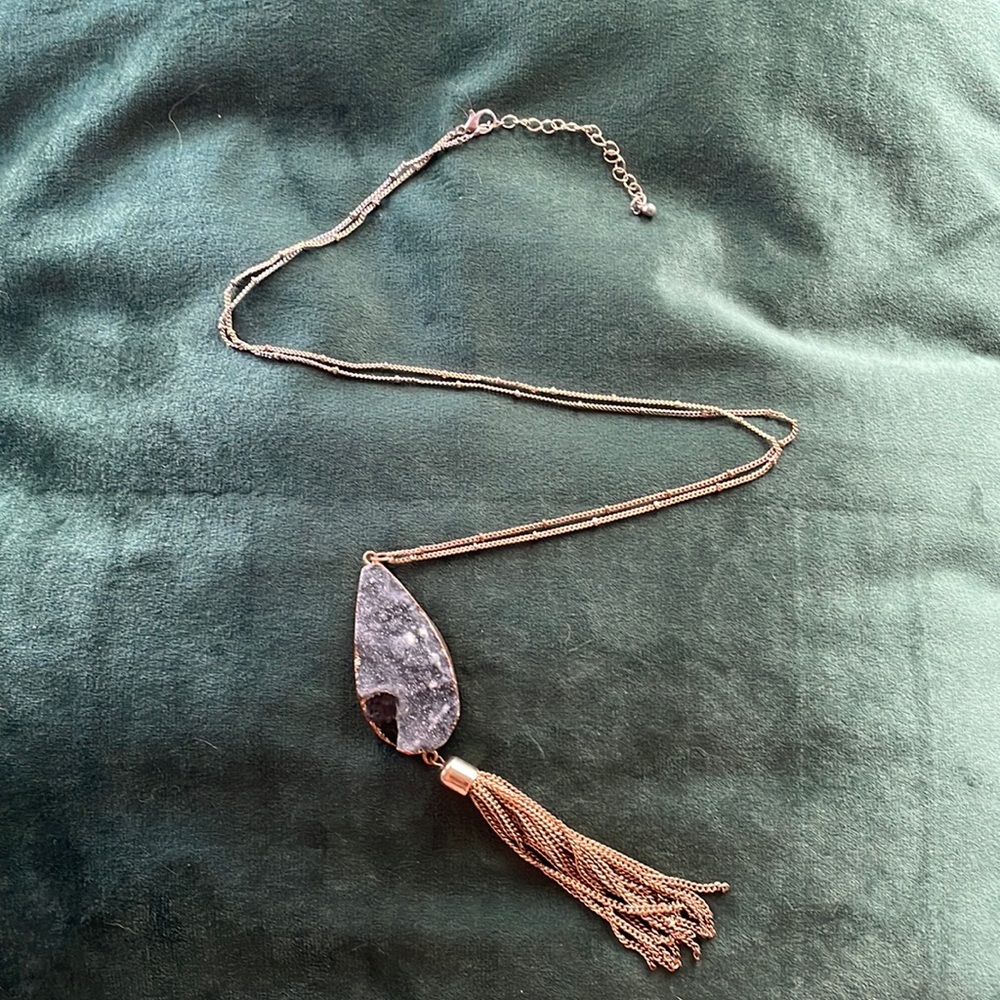 Long gold necklace with gray stone pendant and gold chain tassel